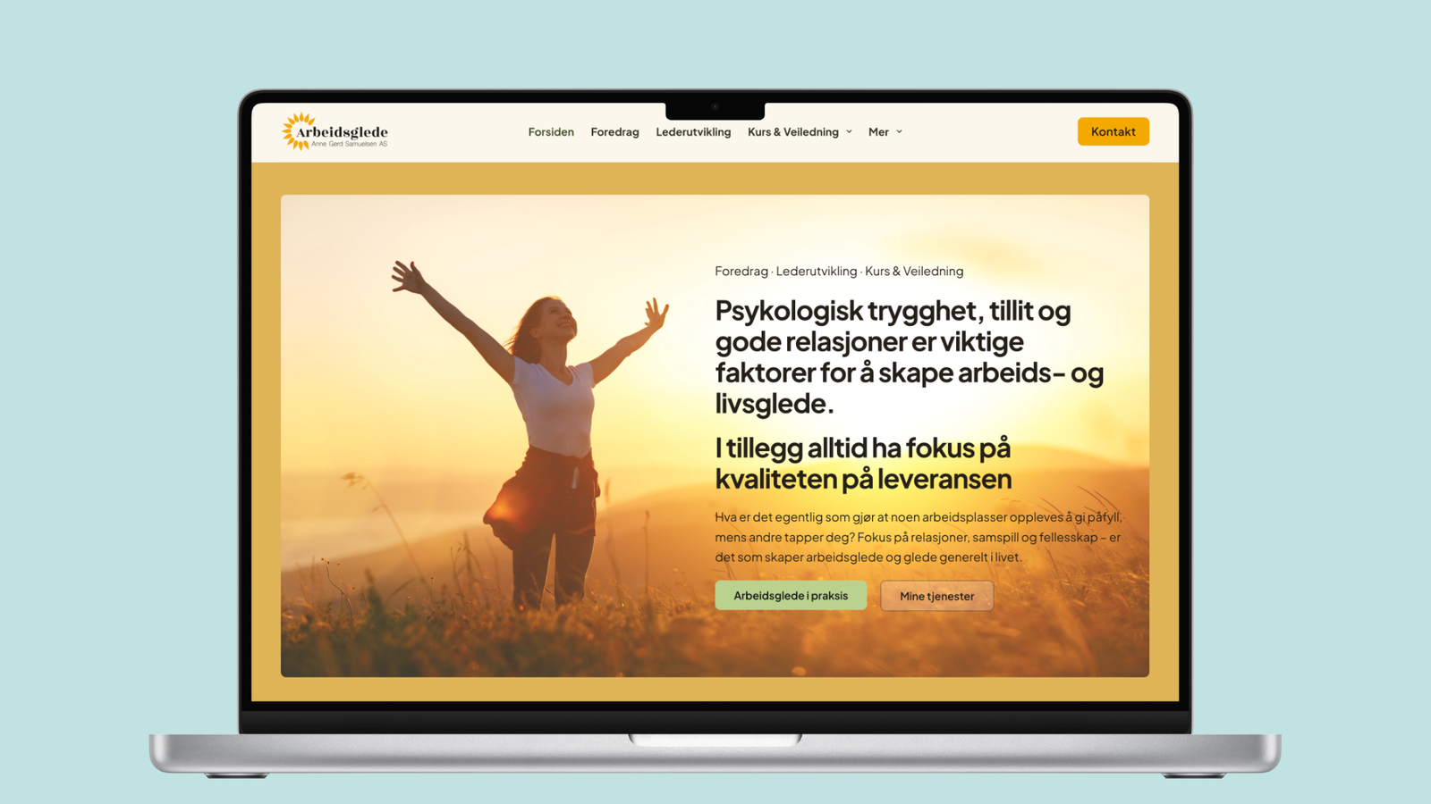 Forsiden av arbeidsglede.com vist på en laptop, med en kvinne som strekker armene ut i et solbelyst landskap ved siden av overskriften «Psykologisk trygghet, tillit og gode relasjoner er viktige faktorer for å skape arbeids- og livsglede.» og knappene «Arbeidsglede i praksis» og «Mine tjenester».